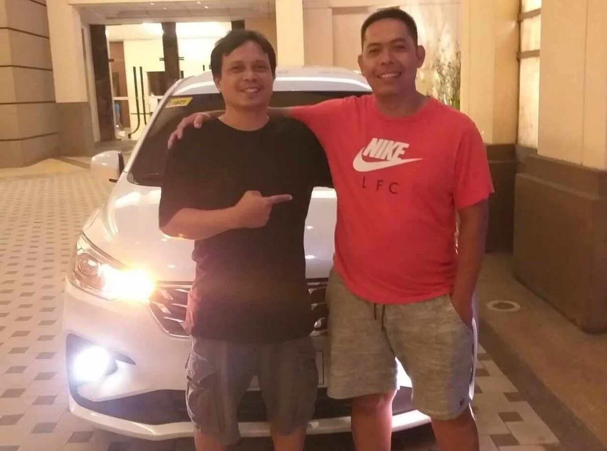 RON The Go Tours and Services founders in front of a white car rental in Cebu